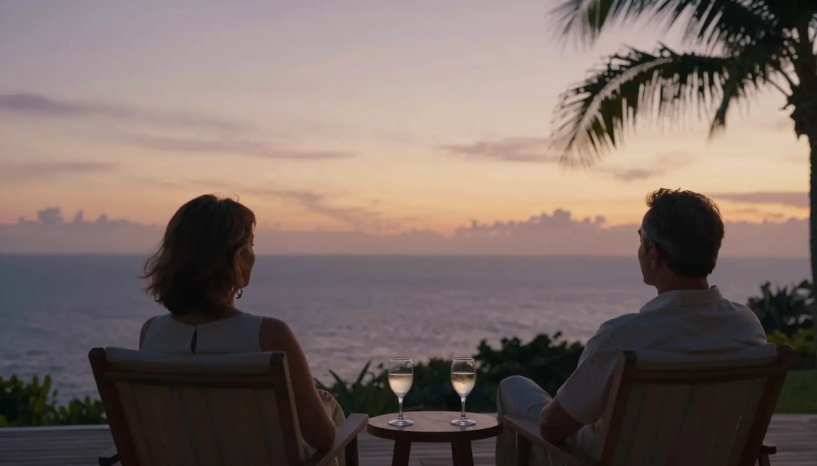 A couple on a private villa deck at sunset